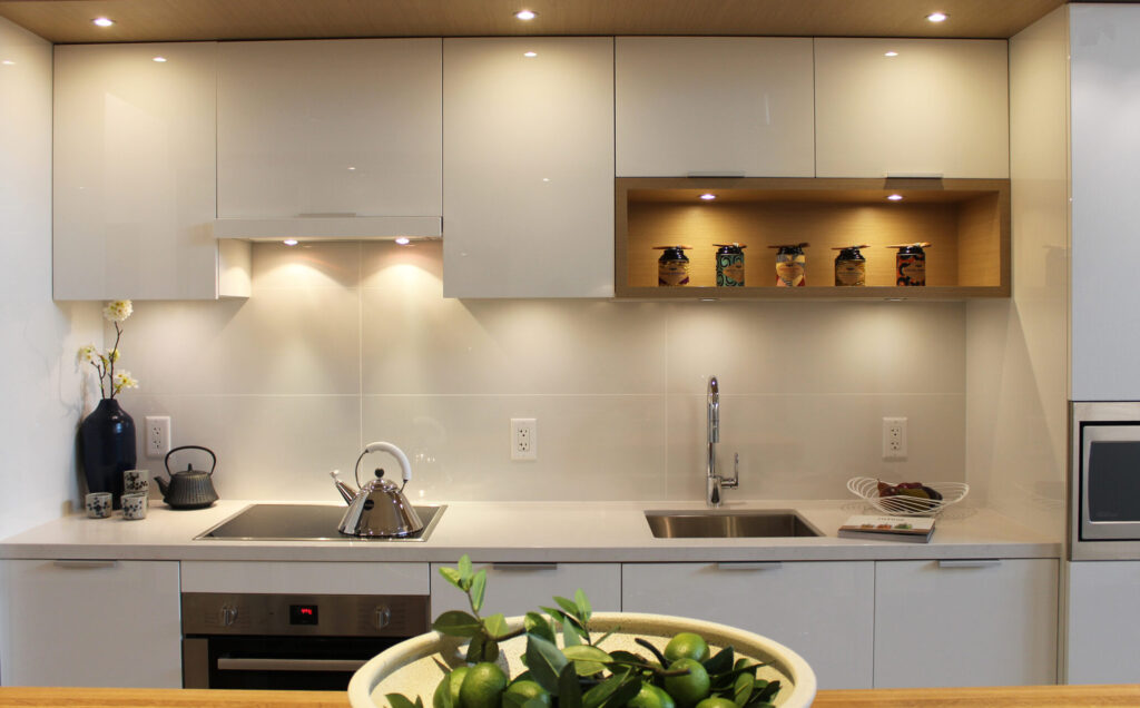 Tủ bếp hiện đại chất liệu acrylic bóng gương màu trắng, kết hợp đèn led âm – xu hướng luxury 2025